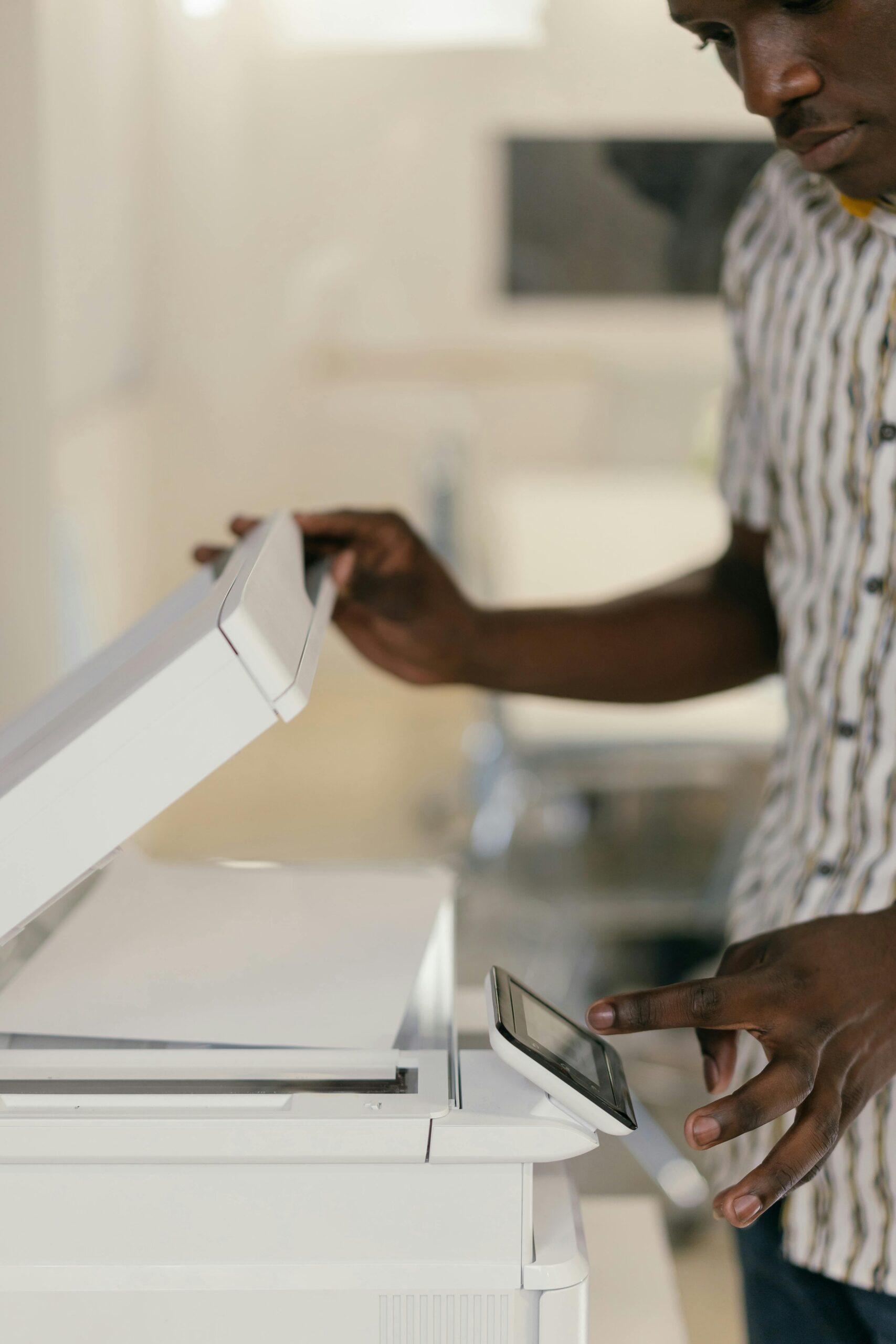 A person using a modern multifunction printer as part of a managed print service, scanning or printing documents with a touchscreen interface.